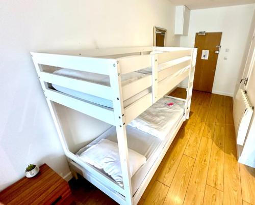 een wit stapelbed in een kamer met een houten vloer bij V07 Fantastic Apt - 100m from Piccadilly Circus in Londen