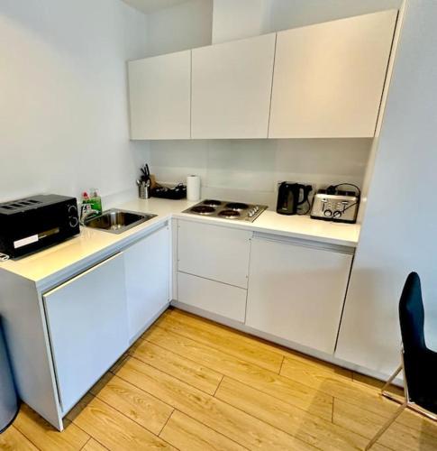 een keuken met witte kasten en een wastafel bij V07 Fantastic Apt - 100m from Piccadilly Circus in Londen