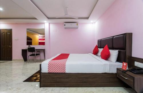 Fun and Food Resort & Holidays في Harsola: غرفة نوم بسرير كبير ومخدات حمراء
