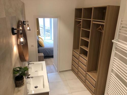 une salle de bain avec un lavabo et une chambre avec un lit dans l'établissement Appartement T3 Hippocrate 106 m2 centre-ville, à Aix-les-Bains