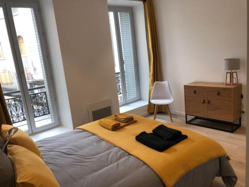 une chambre avec un lit avec deux serviettes dessus dans l'établissement Appartement T3 Hippocrate 106 m2 centre-ville, à Aix-les-Bains