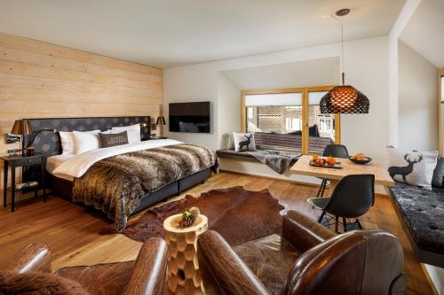 Chalet Piz Buin في كلوسترز: غرفة نوم مع سرير وغرفة معيشة