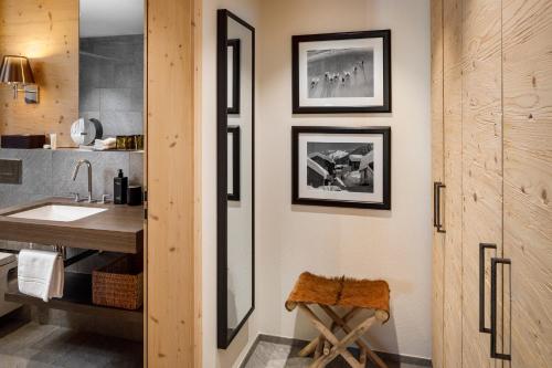 Chalet Piz Buin في كلوسترز: حمام مع مغسلة وطاولة وكاونتر