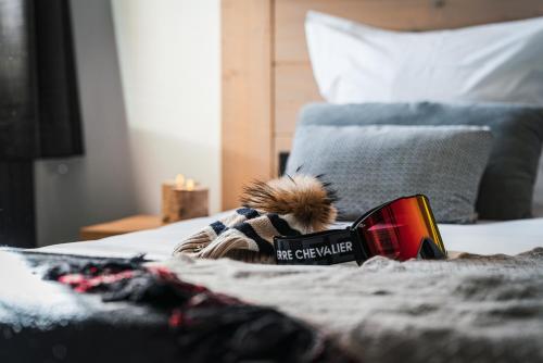 a book sitting on top of a bed with a blanket at Grand Hôtel & Spa NUXE Serre Chevalier in Saint-Chaffrey