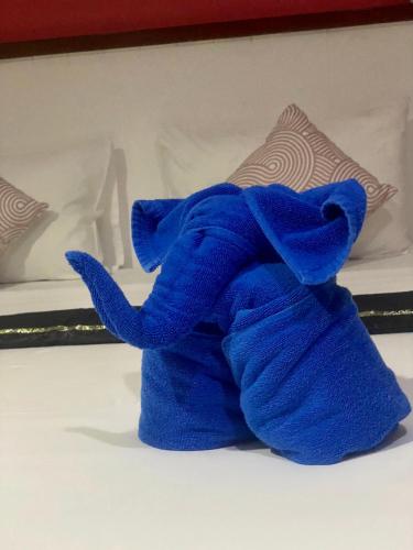 a blue stuffed animal sitting on a bed at Kata Guesthouse Tuscany in Kata Beach