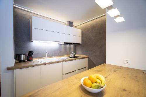 a kitchen with a bowl of fruit on a wooden table at Chasa Tulai F83 in Scuol