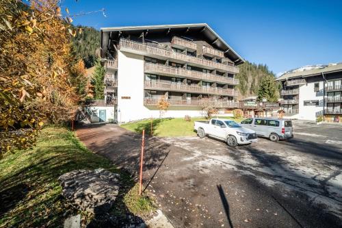 two cars parked in a parking lot in front of a building at Studio Chatel - Au pieds du Linga in Châtel