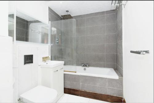 een badkamer met een bad, een toilet en een wastafel bij City Airport, ExCel, Univ of East London, O2 in Londen
