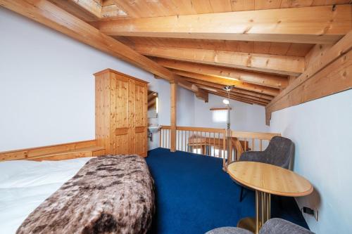 a bedroom with a bed and a wooden ceiling at Hotel Bünda Davos in Davos