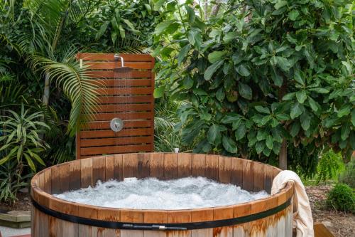 a wooden tub filled with water in a garden at Captain's Haven - oceanstays in Yamba