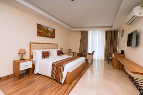 a hotel room with a bed and a television at The Hut Restaurant & Boutique Hotel in Kigali