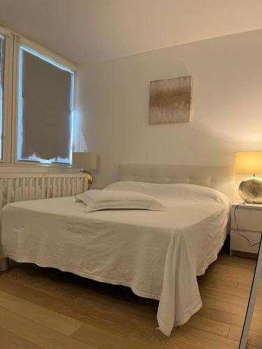 un lit blanc dans une chambre avec une fenêtre dans l'établissement Appartement 2 pièces à Boulogne (porte de Paris), à Boulogne-Billancourt