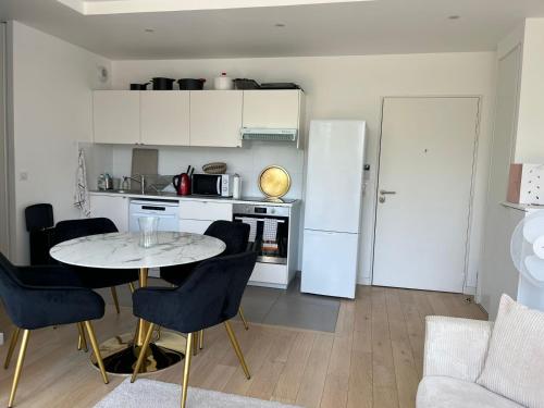 une cuisine avec une table et des chaises dans une pièce dans l'établissement Appartement 2 pièces à Boulogne (porte de Paris), à Boulogne-Billancourt