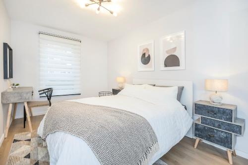a white bedroom with a bed and a desk at The Ivyhouse Lodge in Dagenham