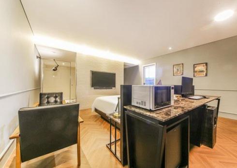 a hotel room with a bed and a microwave at Ulsan Samsan Pandora Hotel in Ulsan