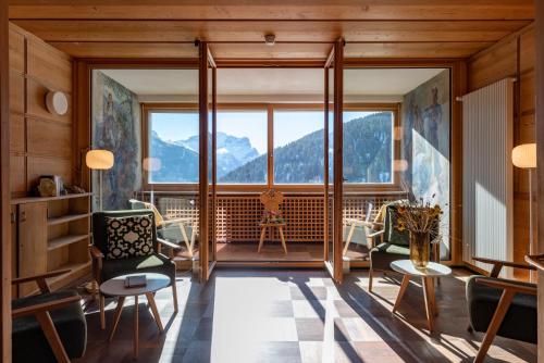 a living room with a large window and chairs at Hotel Restaurant Capricorns in Wergenstein