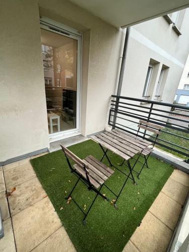 2 bancs assis sur une terrasse avec pelouse dans l'établissement Charmant T2 + parking et balcon, à Strasbourg