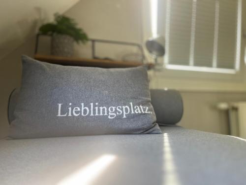 a pillow on a bed with the words litzlingspax on it at "Zonnekind" Atmospheric holiday home in Noordwijkerhout near the beach in Noordwijkerhout