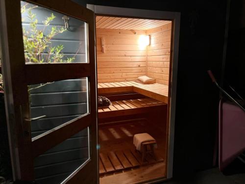 een kleine houten sauna met een bankje erin bij "Zonnekind" Atmospheric holiday home in Noordwijkerhout near the beach in Noordwijkerhout