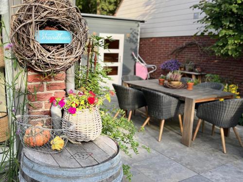 a patio with a table and a basket of flowers at "Zonnekind" Atmospheric holiday home in Noordwijkerhout near the beach in Noordwijkerhout