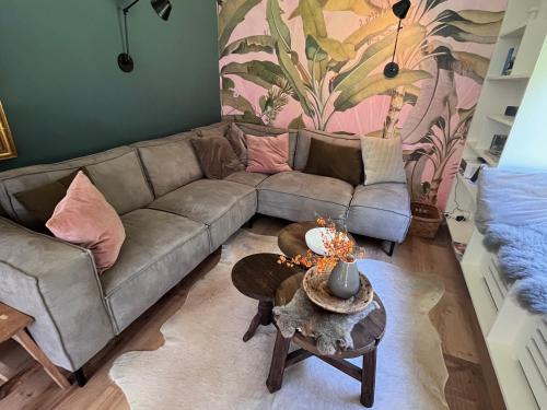 a living room with a couch and a table at "Zonnekind" Atmospheric holiday home in Noordwijkerhout near the beach in Noordwijkerhout