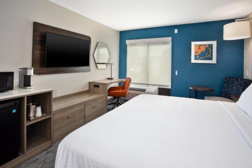 a hotel room with a bed and a flat screen tv at Holiday Inn Express Kitty Hawk - Outer Banks by IHG in Kitty Hawk