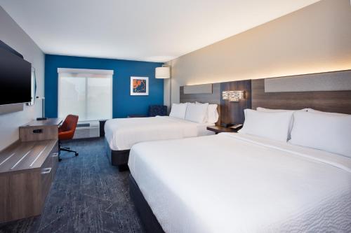a hotel room with two beds and a flat screen tv at Holiday Inn Express Kitty Hawk - Outer Banks by IHG in Kitty Hawk