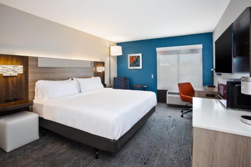 a hotel room with a bed and a flat screen tv at Holiday Inn Express Kitty Hawk - Outer Banks by IHG in Kitty Hawk