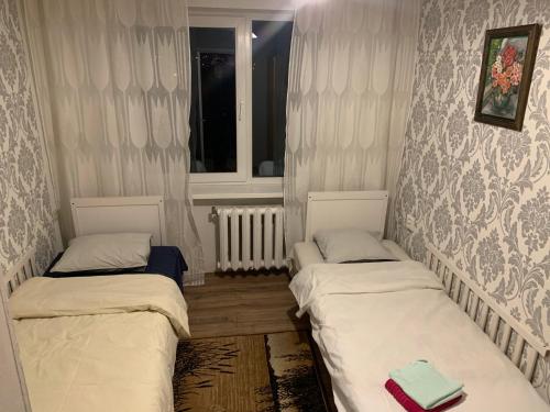 two twin beds in a room with a window at Jalaka, Nice 2-bedroom apartment - 1 big bed - 2 single bed in Tartu