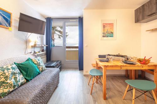 un salon avec un canapé et une table en bois dans l'établissement Le Schuss, à Chamrousse