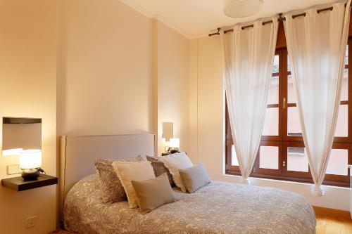 a bedroom with a bed and a large window at Casco Histórico-Catedral in Oviedo