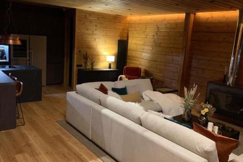 a living room with a white couch and a television at Arttysur Lux Village Sierra Nevada Casa 8 Superlujo in Sierra Nevada