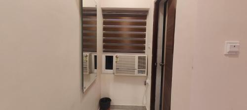 La salle de bains est pourvue d'un miroir et d'une fenêtre avec la climatisation. dans l'établissement Hotel Jayadeep, à Bhubaneswar