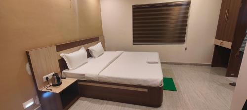 - un lit dans une petite chambre avec publicité, dans l'établissement Hotel Jayadeep, à Bhubaneswar