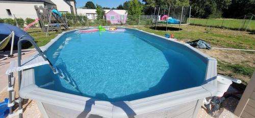 une grande piscine dans une cour arrière dans l'établissement Chambres Logement 130m2 - Circuit 24h Le Mans, à Arnage