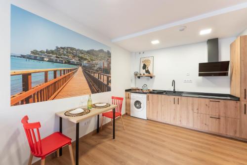 a kitchen and dining room with a view of the ocean at Sausalito Canteras by Canarias Homelidays in Las Palmas de Gran Canaria