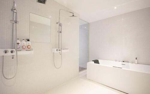 a white bathroom with a shower and a sink at Ulsan Samsan Pandora Hotel in Ulsan