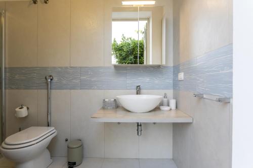 a bathroom with a sink and a toilet at Villa Alexandra - IsulaTravel in Ispica