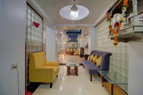 OYO SilverKey Hotel Manas Residency في مومباي: غرفة معيشة مع كرسيين وطاولة