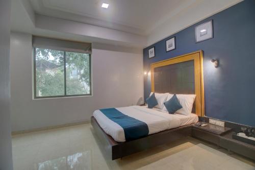 Säng eller sängar i ett rum på OYO SilverKey Hotel Manas Residency