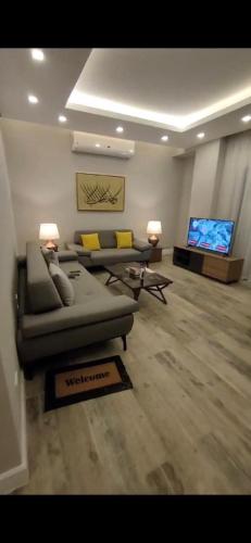a living room with couches and a flat screen tv at Maison 7 New Cairo in Cairo