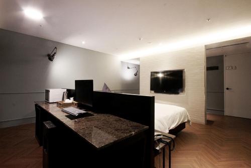 a bedroom with a bed and a desk with a computer at Ulsan Samsan Pandora Hotel in Ulsan