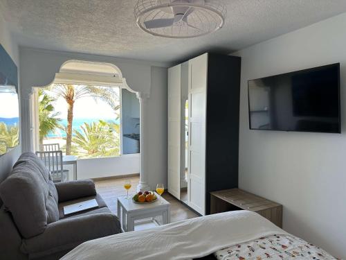 a bedroom with a bed and a couch and a tv at Studios für 2 Personen am Strand in Arguineguín