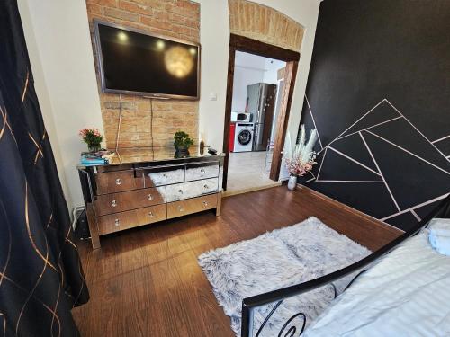 a bedroom with a dresser with a television on a wall at Central Station Apartment in Cluj-Napoca