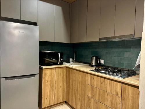a kitchen with wooden cabinets and a refrigerator at Downtown Apartment in Kutaisi