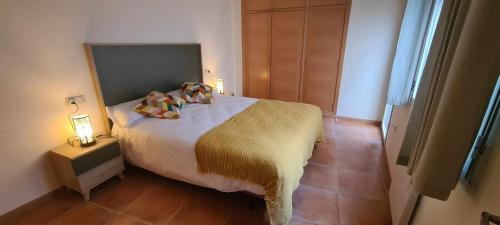 a bedroom with a bed and a lamp on a table at Apartamento Bronce in Riópar