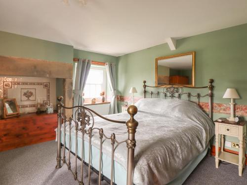a bedroom with a bed and a mirror on the wall at High Shaftoe in Longwitton