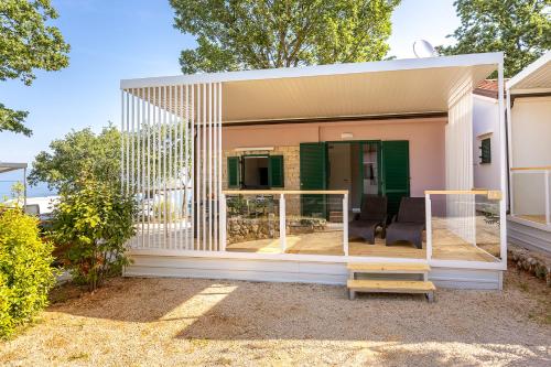 a house with a screened in porch at Camping Glavotok in Krk