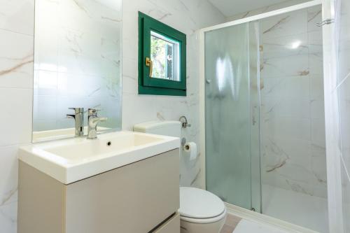 biała łazienka z umywalką i prysznicem w obiekcie Camping Glavotok w Krku