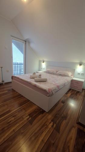 a large bed in a room with a wooden floor at Apartments Katarina in Zlatibor